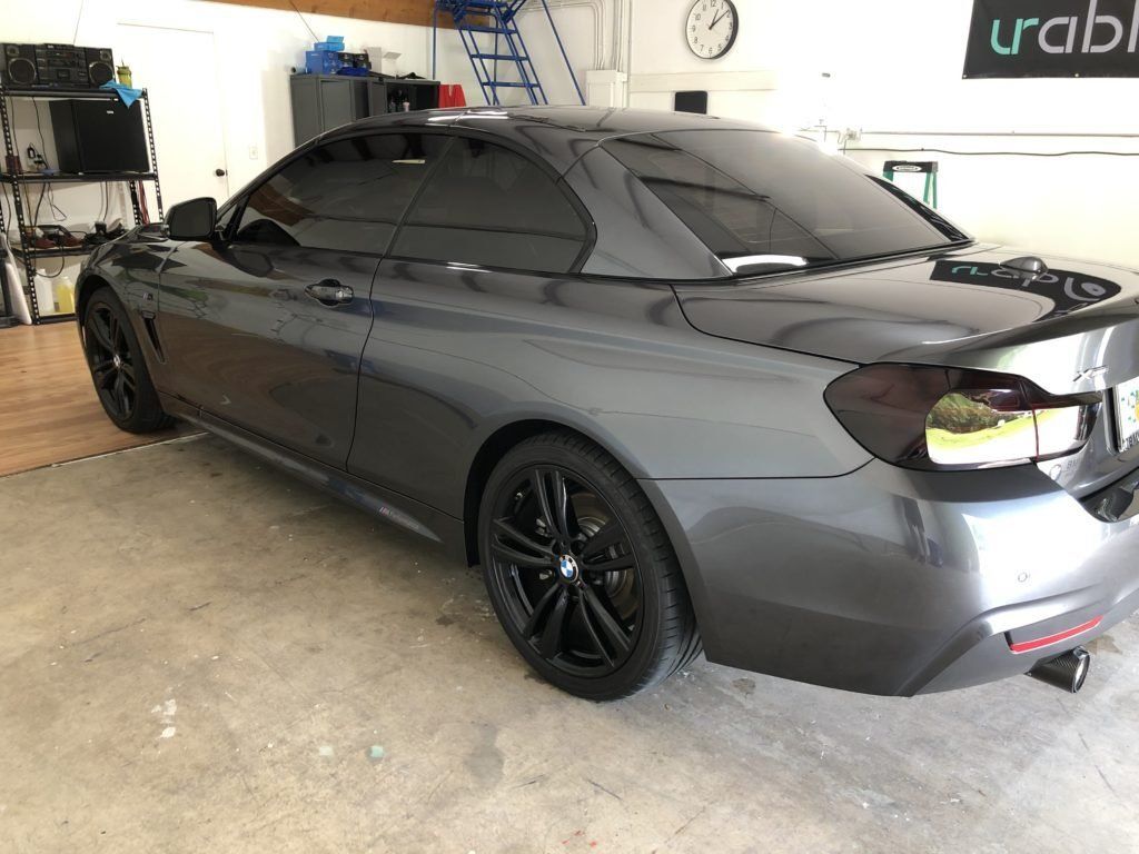 A gray bmw is parked in a garage.
