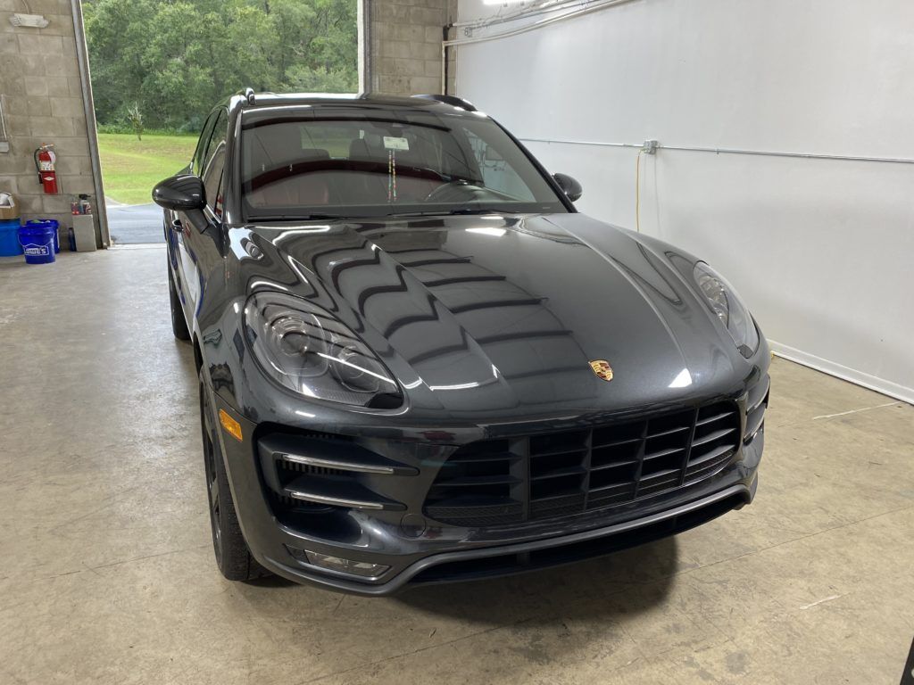 A black porsche macan turbo is parked in a garage.