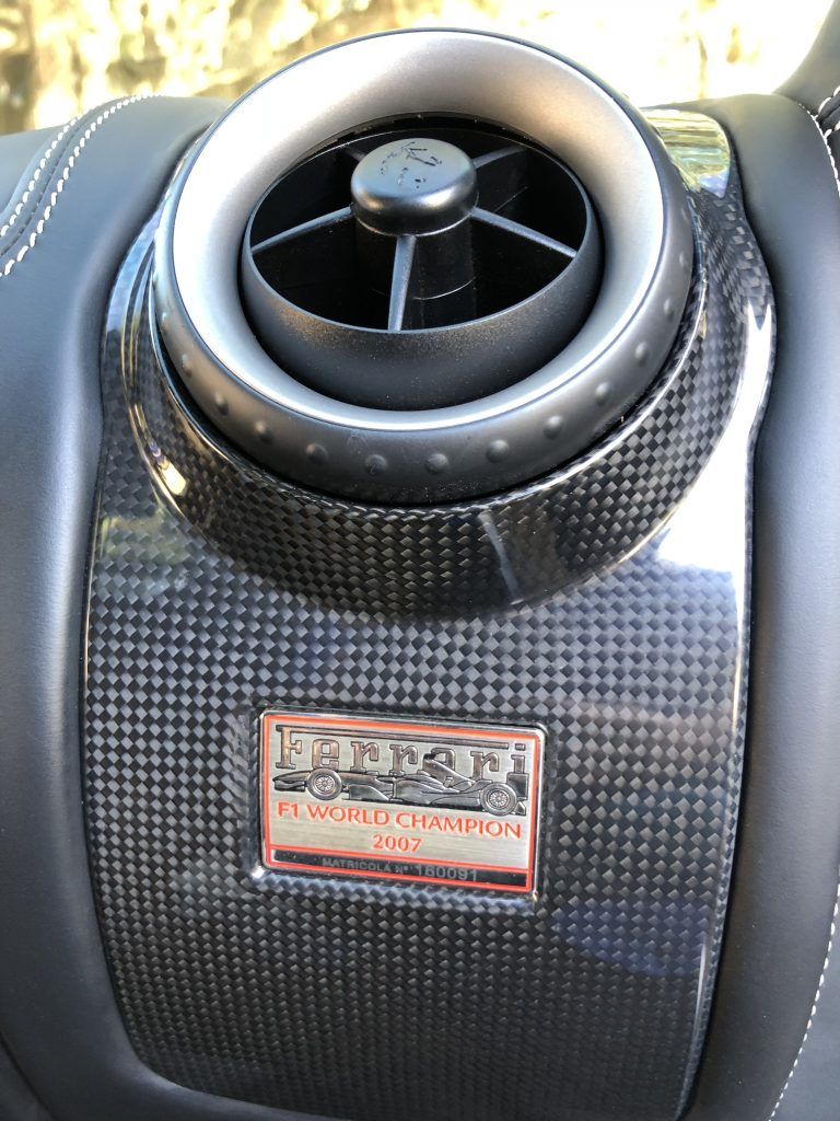 A car air vent with a ferrari logo on it