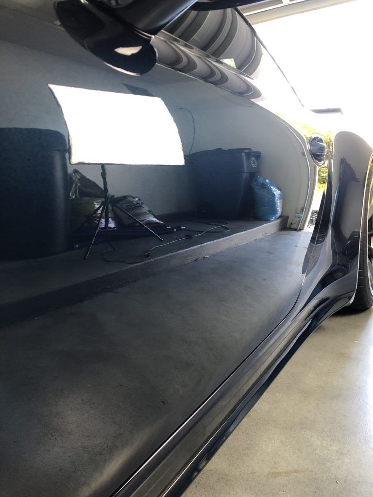 A black car is parked in a garage.