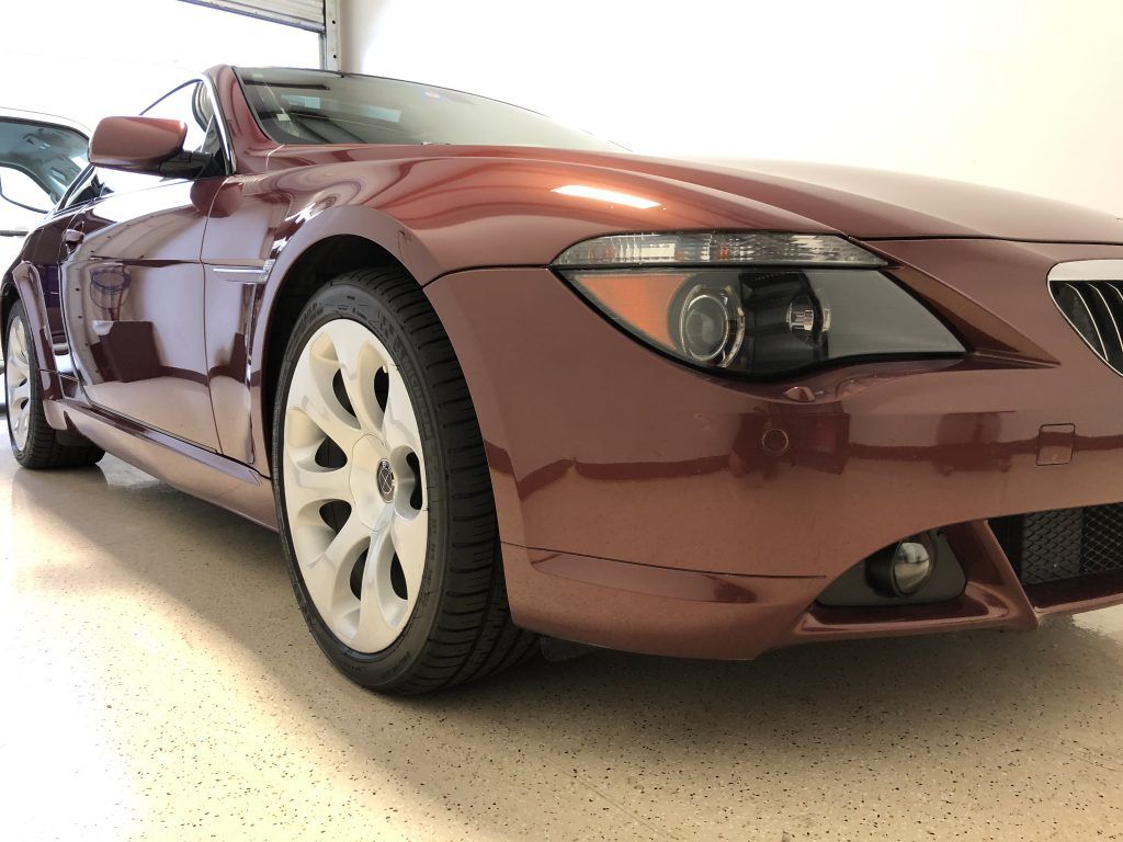 A red sports car is parked in a garage.