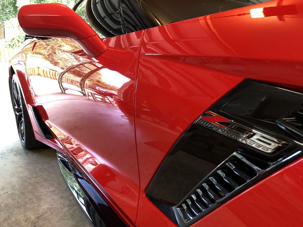 A red sports car is parked in a garage