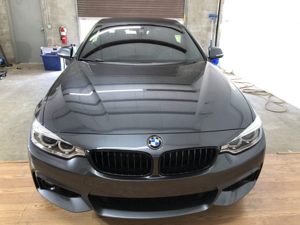 A black bmw is parked in a garage.