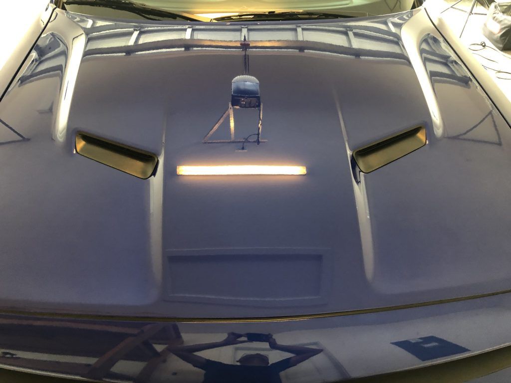 A close up of the hood of a blue car