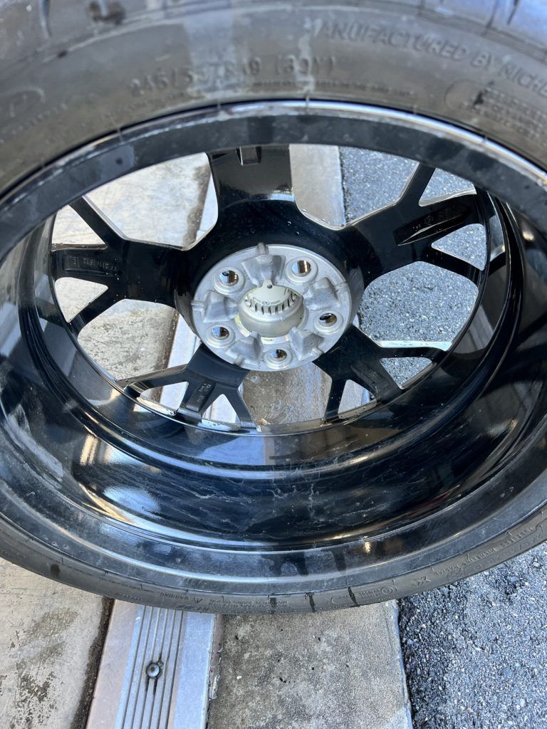 A close up of a tire on a wheel on a concrete surface.