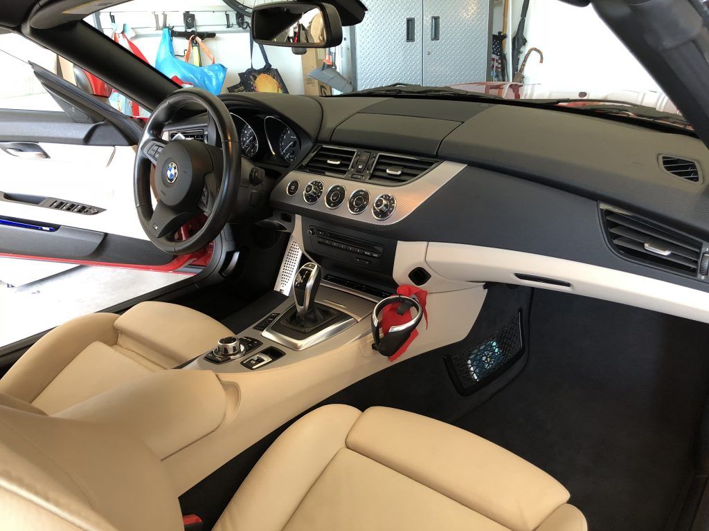 The interior of a sports car with the hood up in a garage.