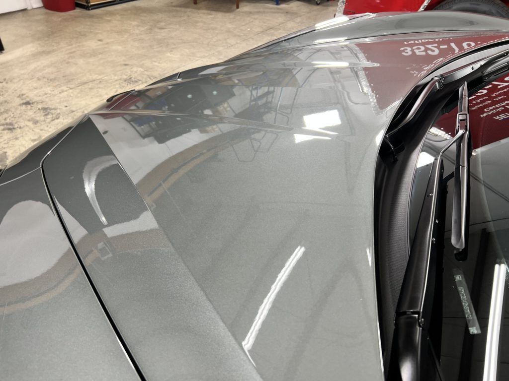 A close up of the hood of a car in a garage.