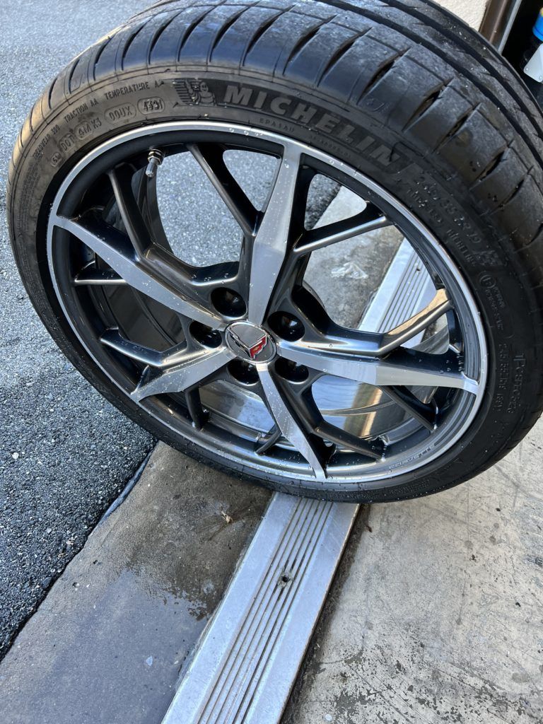 A close up of a michelin tire on a car wheel.