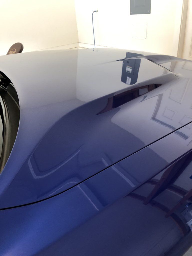 A close up of the hood of a blue car