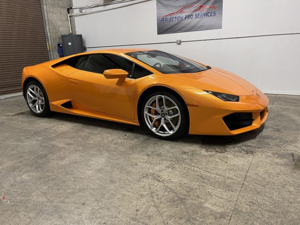 A yellow lamborghini huracan is parked in a garage.
