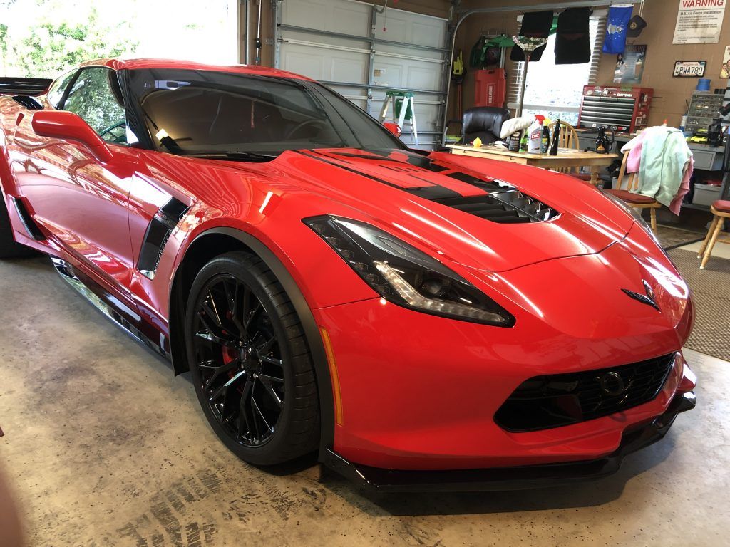 A red sports car is parked in a garage.