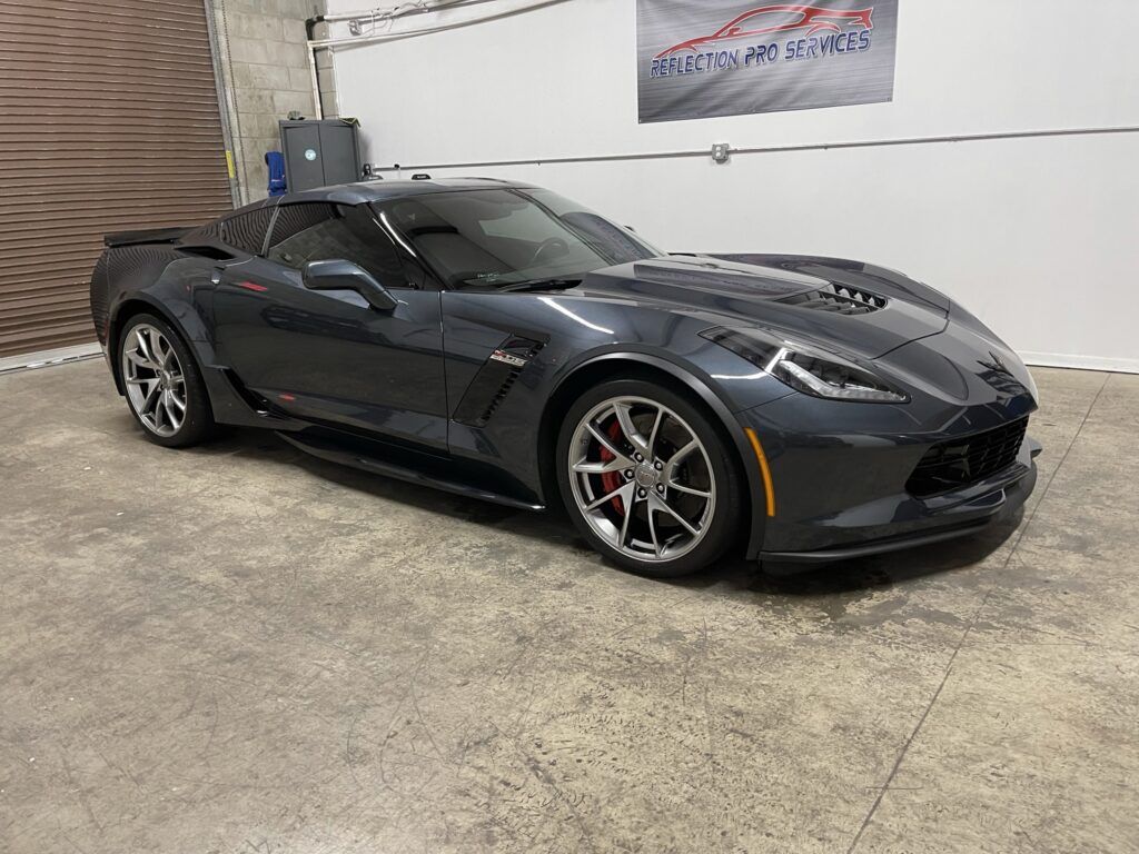 A gray corvette zr1 is parked in a garage.
