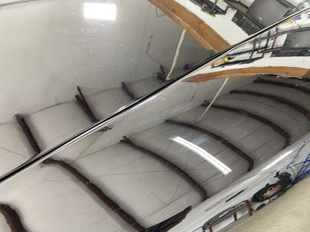 A close up of a car windshield with a reflection of a staircase in it.