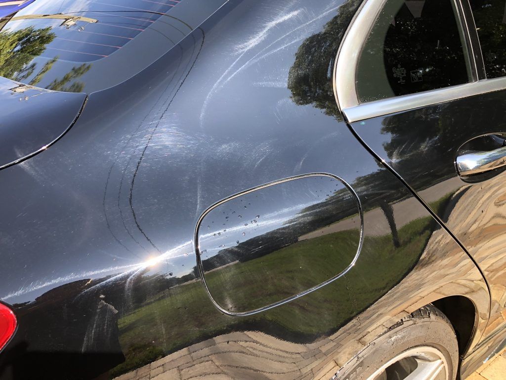 A black car is parked on the side of the road.