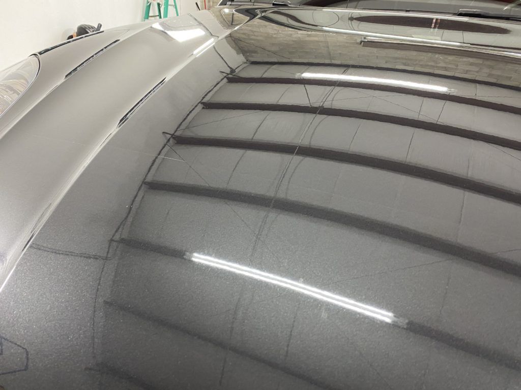 A close up of a car hood in a garage.