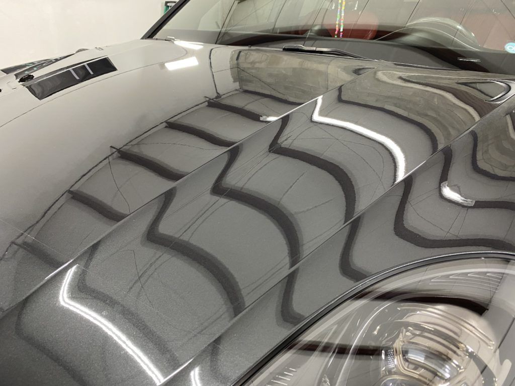 A close up of the hood of a car in a garage.