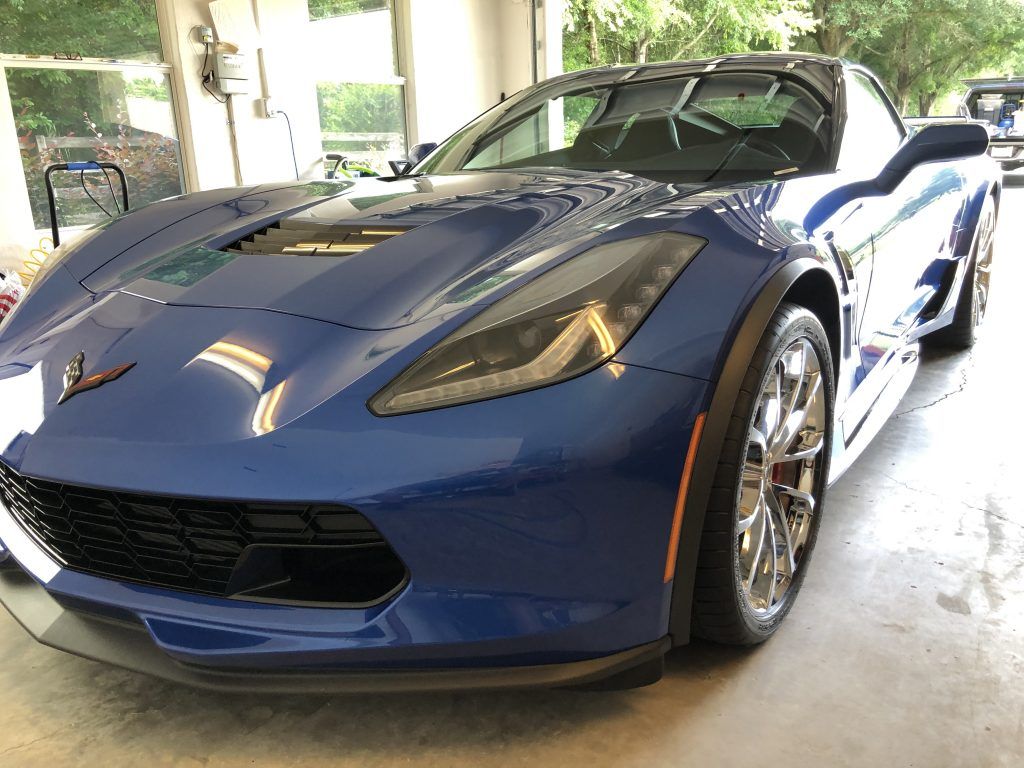 A blue sports car is parked in a garage.