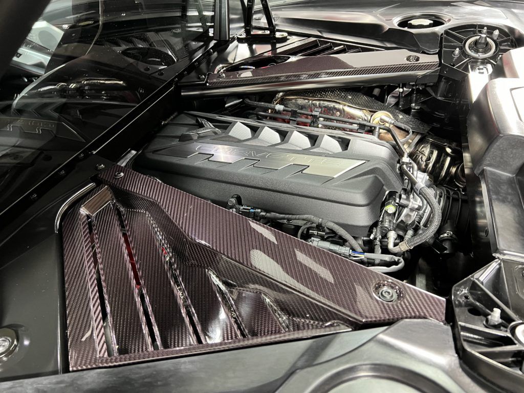 A close up of a car engine with the hood open