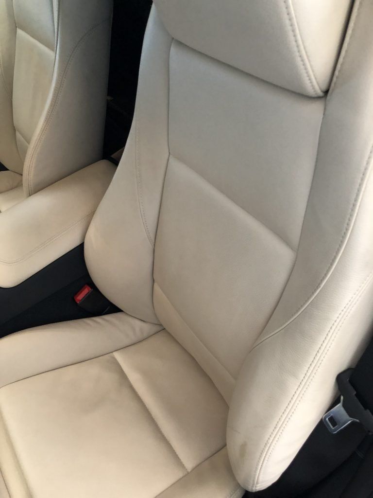 A close up of a white leather seat in a car