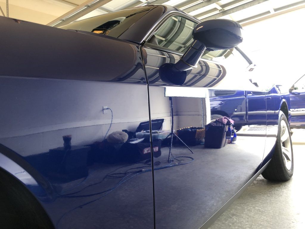 A blue car is parked in a garage.