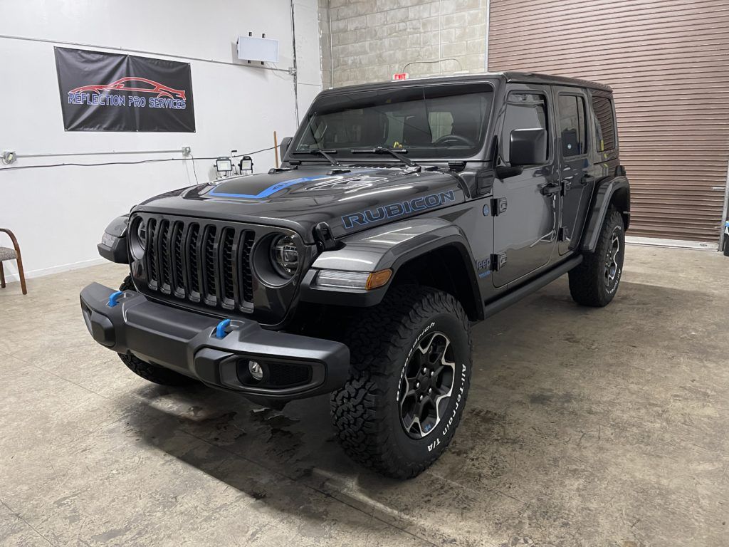A black jeep wrangler is parked in a garage.