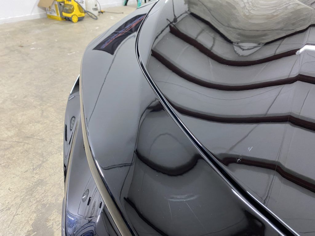 A close up of the hood of a car in a garage.