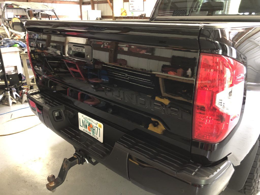 A black toyota tundra truck is parked in a garage.