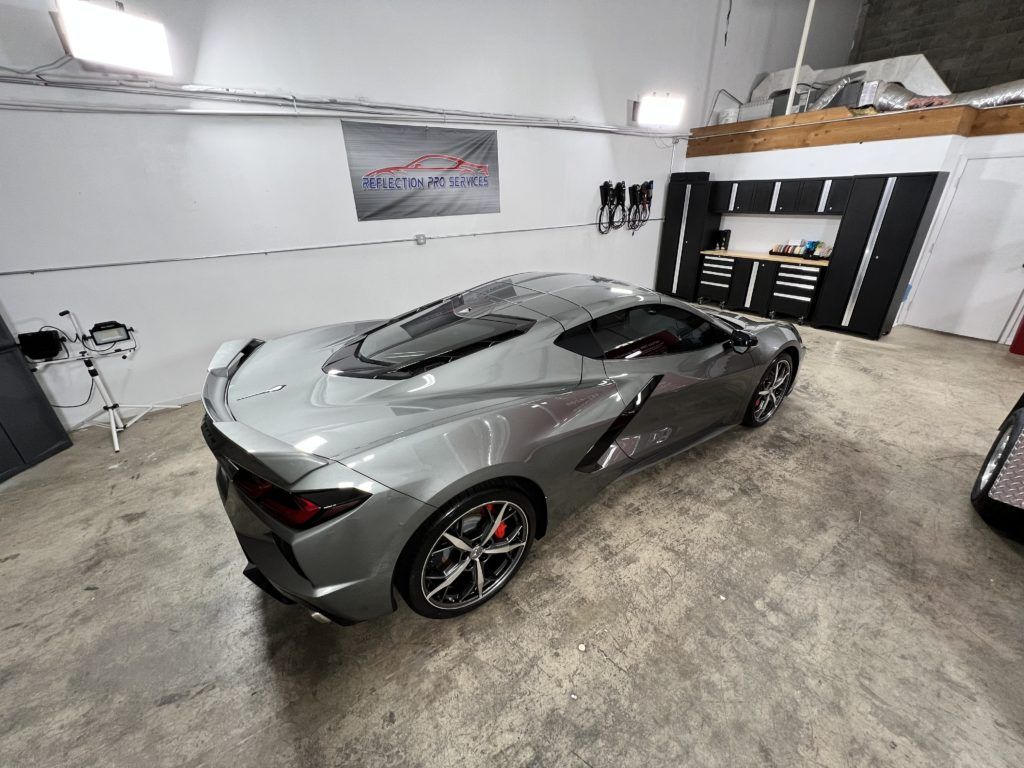 A silver sports car is parked in a garage.