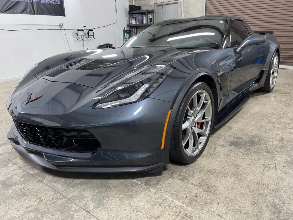 A black corvette zr1 is parked in a garage.