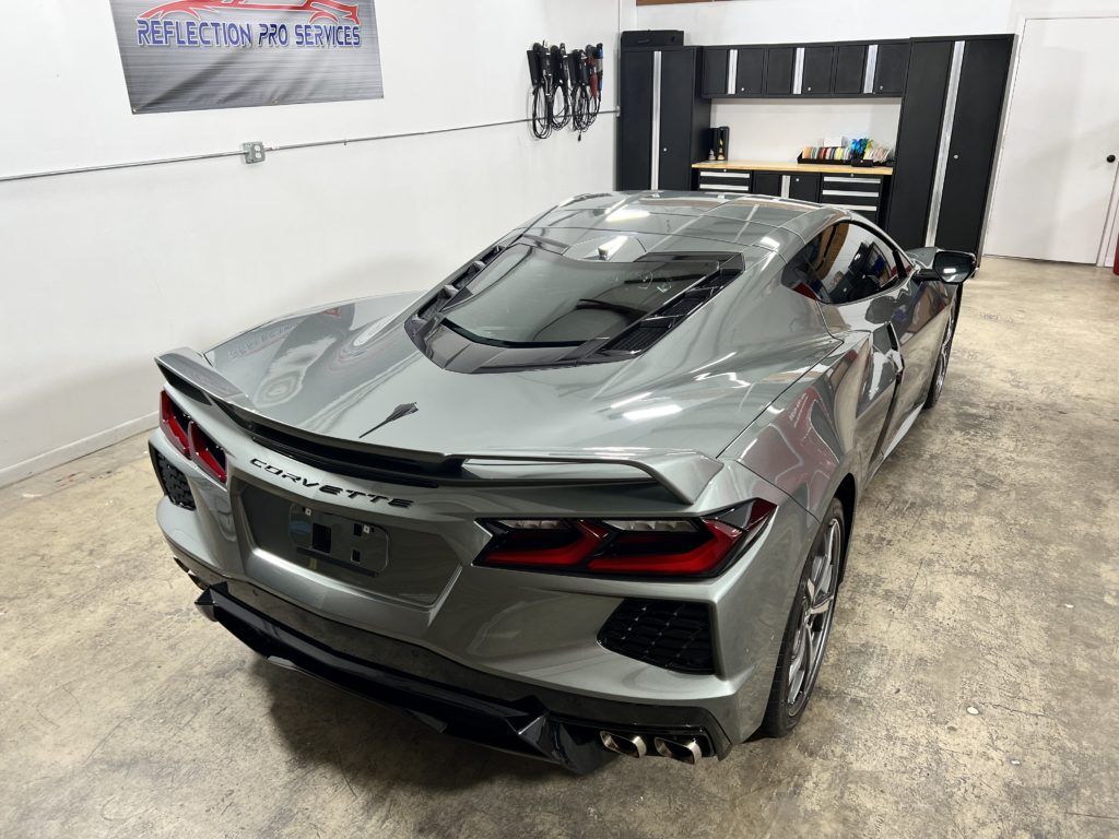 A silver sports car is parked in a garage.
