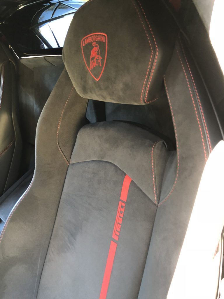 A lamborghini seat with a red stripe on it