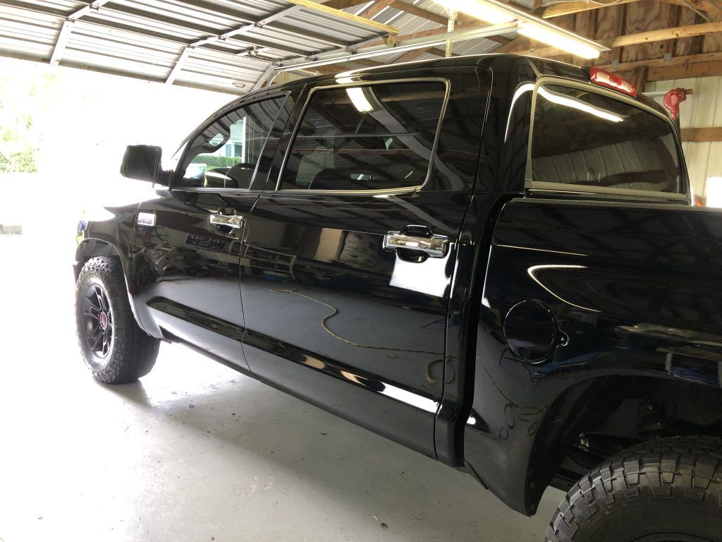 A black truck is parked in a garage.