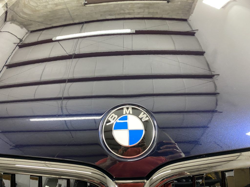 A close up of a bmw logo on the hood of a car