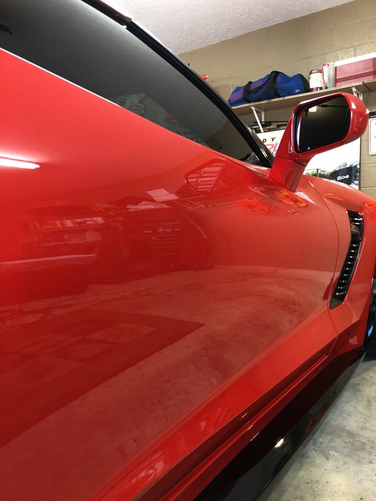 A red sports car is parked in a garage.