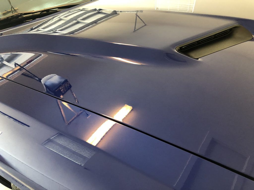 A close up of the hood of a blue car