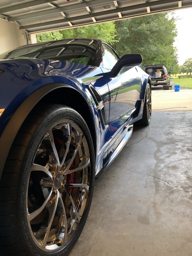 A blue sports car is parked in a garage.