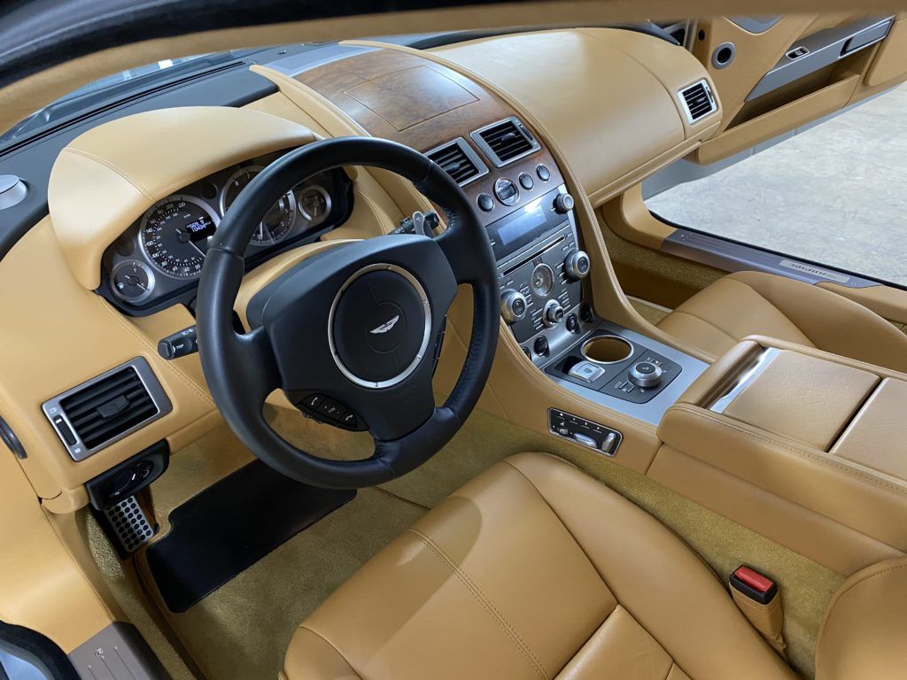 The interior of a car with tan leather seats and a black steering wheel