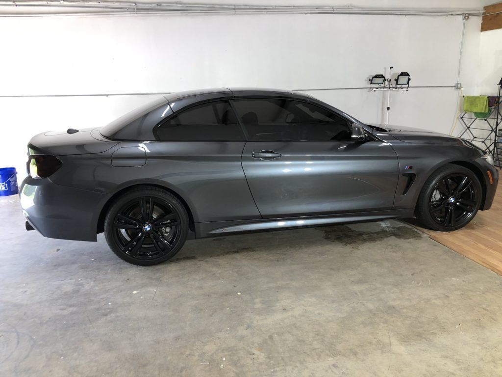 A bmw 4 series convertible is parked in a garage.