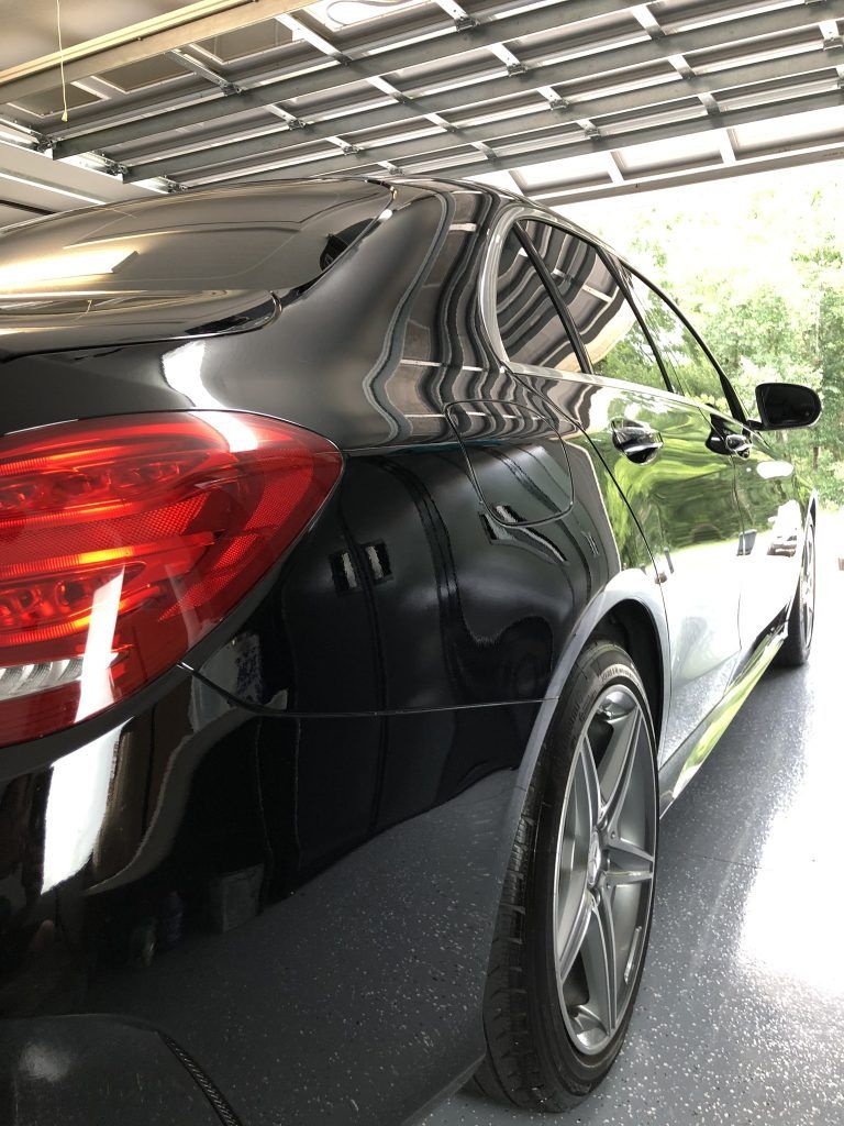 A black car is parked in a garage.