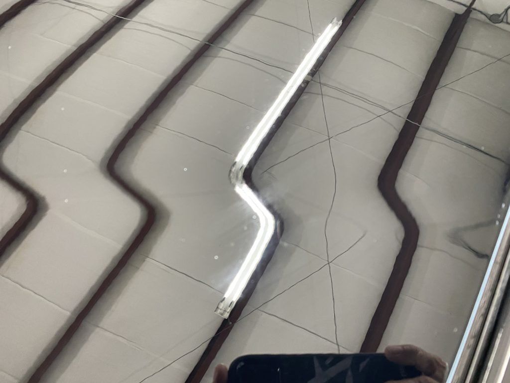 A person is taking a picture of a car with a cell phone