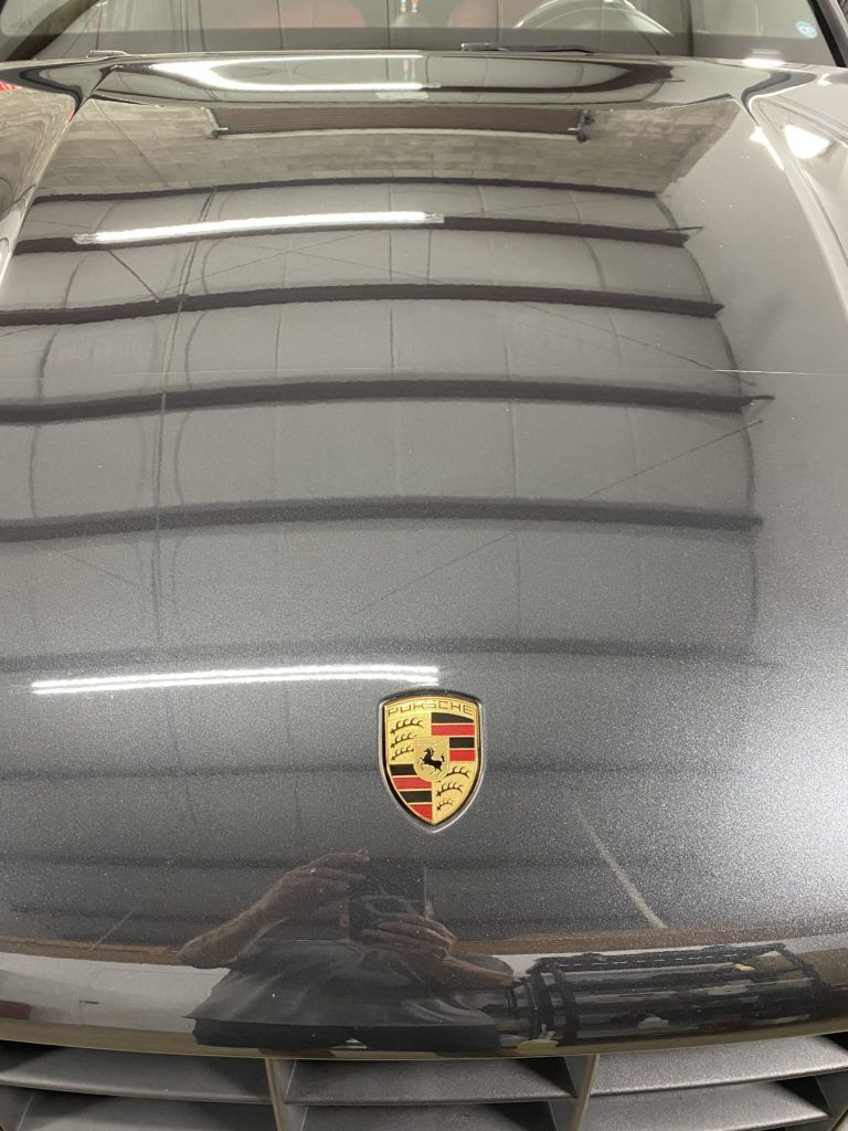 A close up of the hood of a porsche car in a garage.