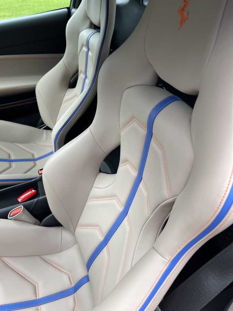 A close up of a car seat with a blue stripe