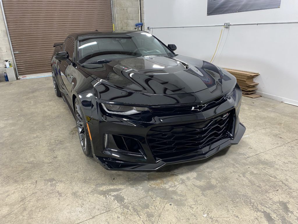 A black chevrolet camaro zl1 is parked in a garage.