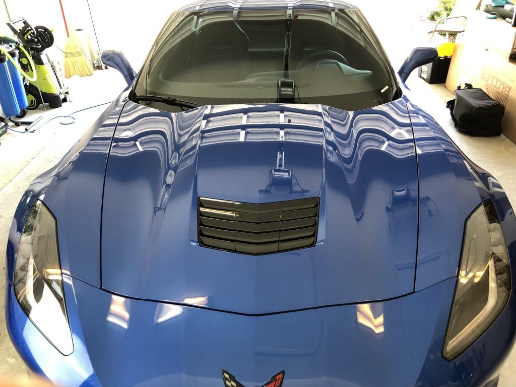 A blue sports car is parked in a garage.