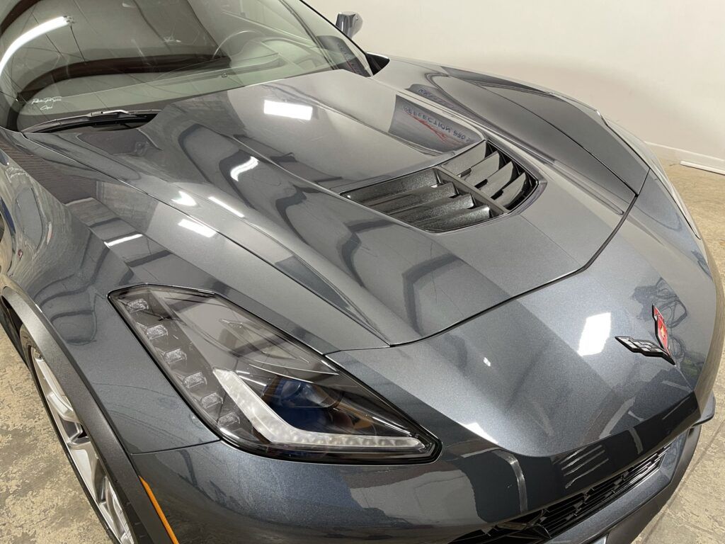 A close up of the hood of a gray sports car.