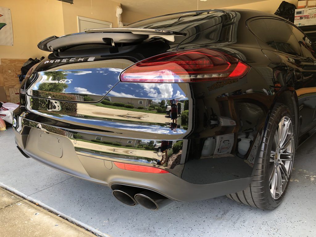 A black sports car is parked in a garage.