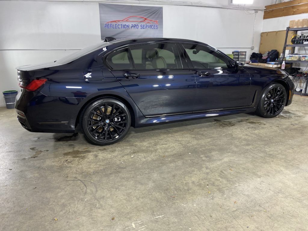 A black bmw 3 series is parked in a garage.