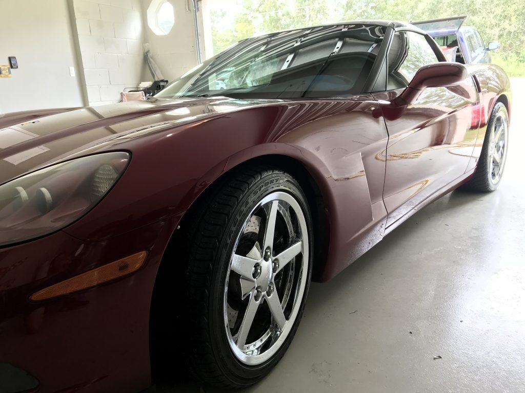 A red sports car is parked in a garage.