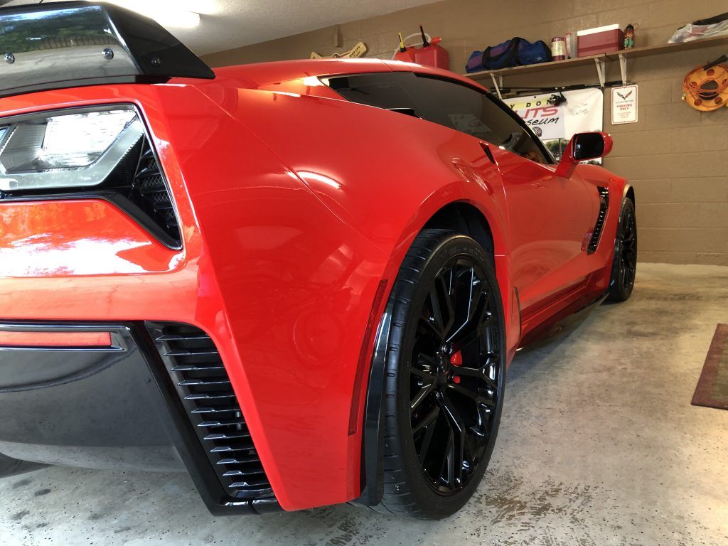 A red sports car is parked in a garage.