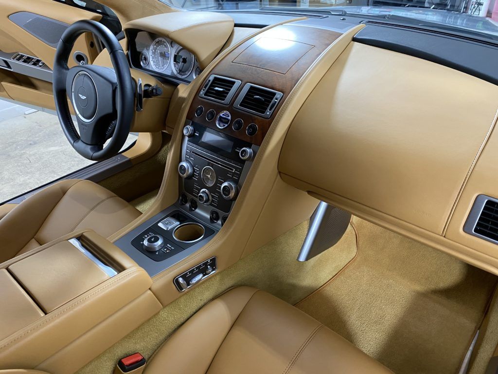 The interior of a car with brown leather seats and a steering wheel.